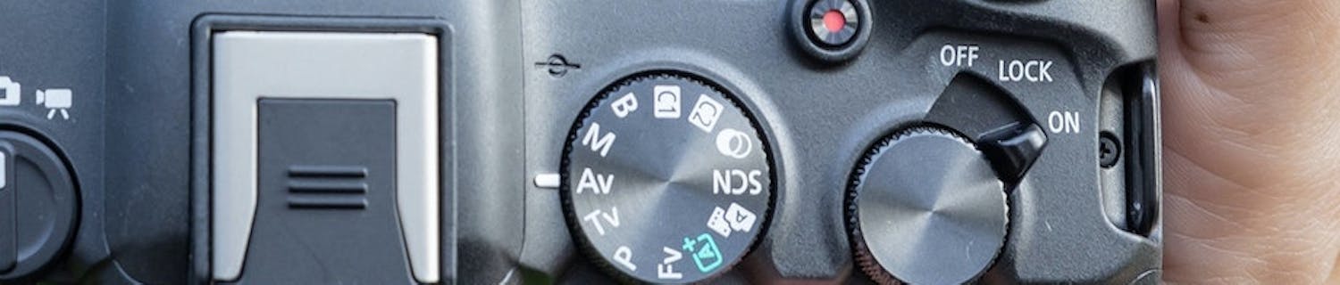 Hand håller en systemkamera